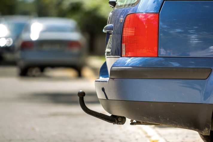 Kyiv, Ukraine - September 16, 2019: Close-up view detail of blue car parked on sunny street, red stop lights and hook for dragging trailer, tow hitch or tow bar on blurred copy space background.; Shutterstock ID 1510555205; purchase_order: -; job: -; client: -
