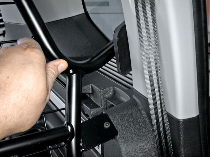   04.
 	Trenngitter mit zweiter Person ins Auto heben und an den Montagepunkten befestigen