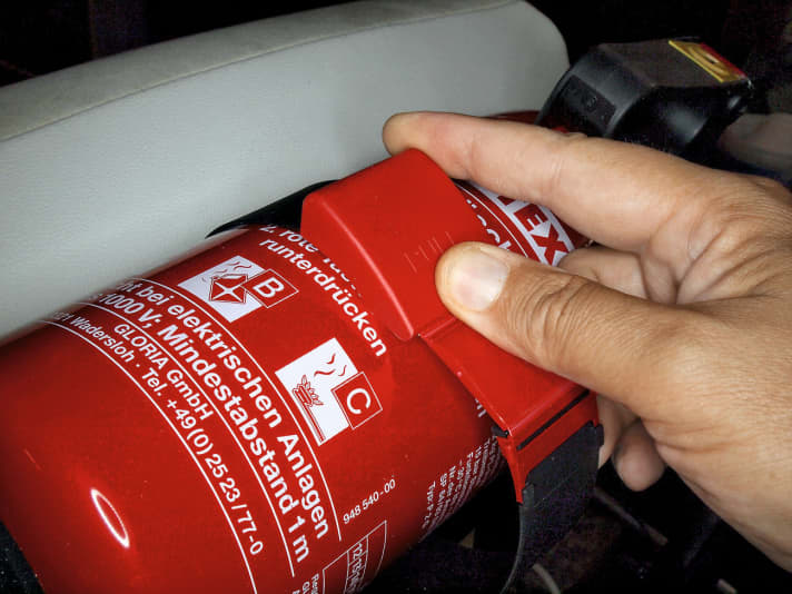   03.
 	Feuerlöscher einsetzen und mit dem zugehörigen Spannband sichern