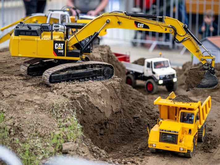 Funktionsmodellbau mit beeindruckendem Realismus: Ein ferngesteuerter Kettenbagger lädt auf der INTERMODELLBAU Erdmaterial in einen Muldenkipper – detailgetreu nach dem Vorbild echter Baustellenabläufe.