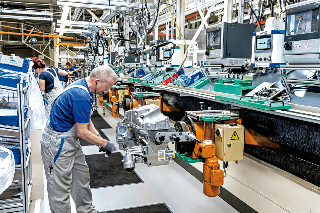 Richard Meissner, am Tischkreis-Förderer bei der Motorenmontage, und Anika Nohl im Hintergrund