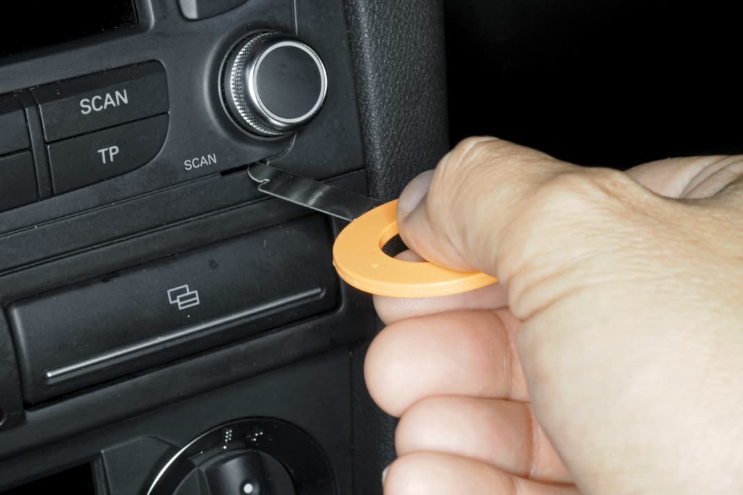 Auszieh-Werkzeuge mit Abflachung nach außen einschieben, dadurch Radio entriegeln