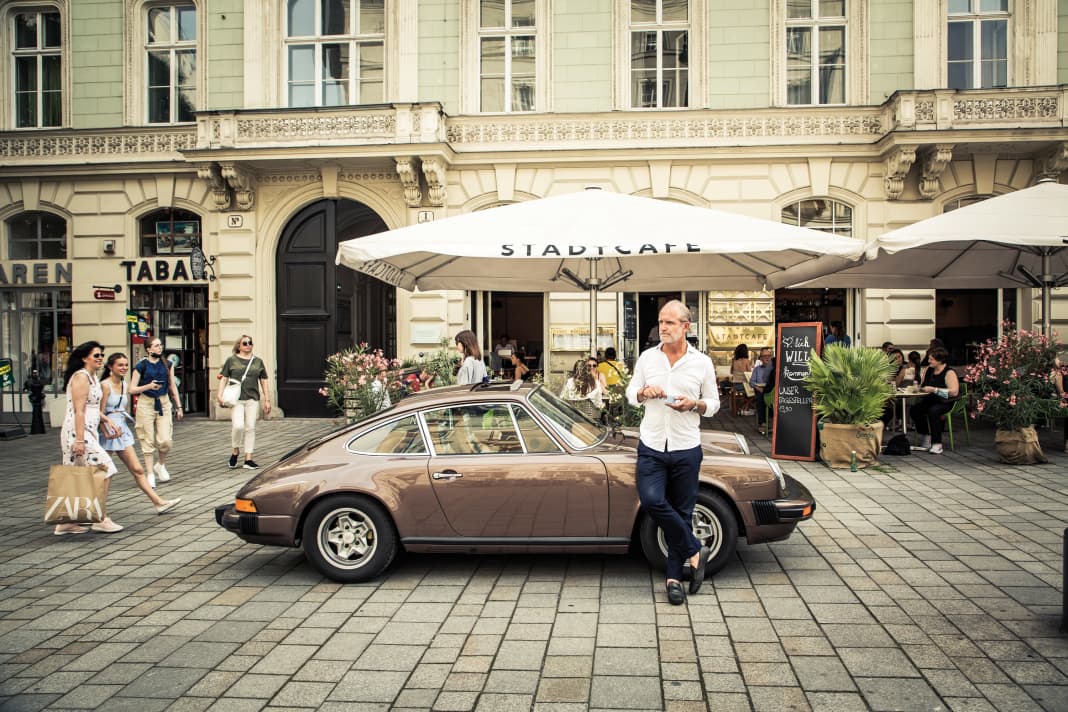 Farbenspiel: Immer wieder dominieren Sandtöne das Wiener Stadtbild.  Hier als Melange mit dem Porsche in Braunkupfermetallic. Und Marcus Görig mit einem Espresso in der Hand.