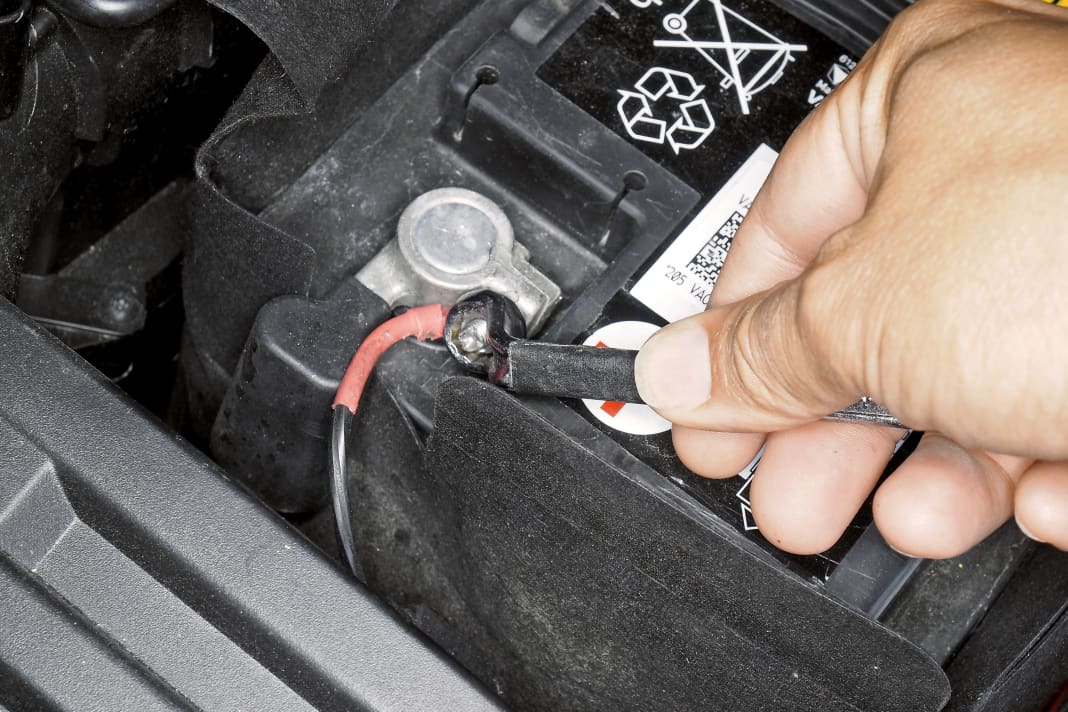Batterie-Abdeckung öffnen, mit Zehner- Steckschlüssel Polklemme vom Pluspol lösen und beiseite klemmen