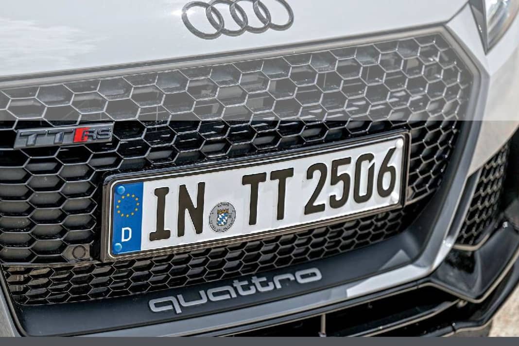 Ein glänzend schwarzer Grill mit matter Singleframe-Einfassung, dazu der titanfarbene Quattro-Schriftzug