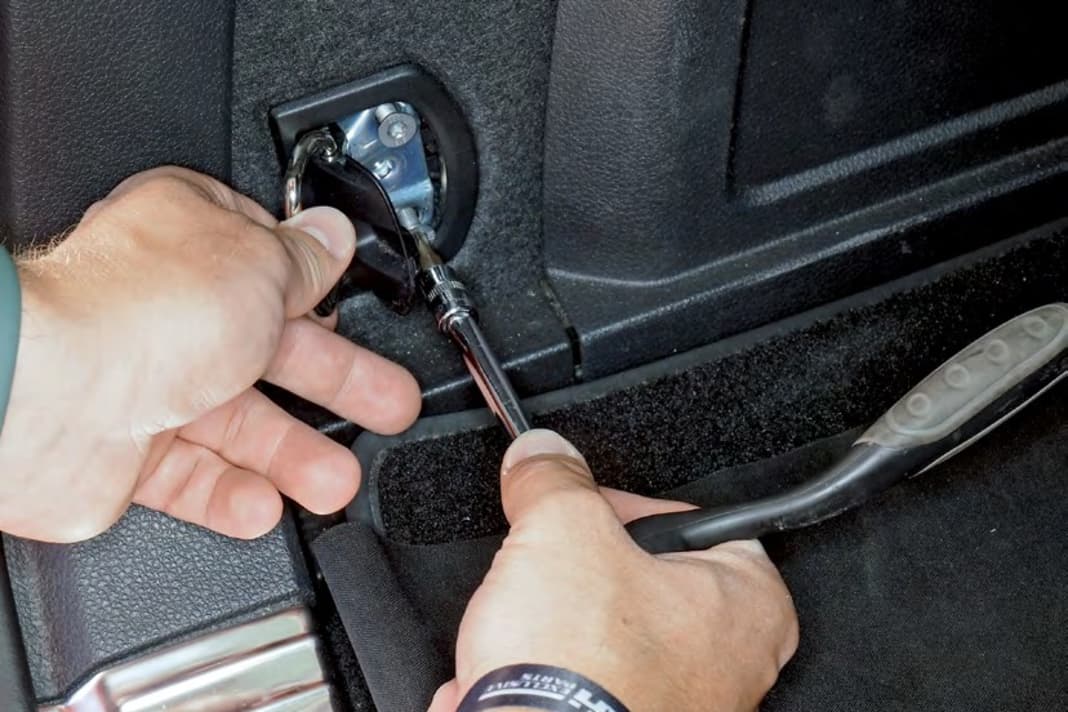 9 An den Zurrösen jeweils die Blende abhebeln und darunter jeweils zwei Schrauben Tx 30 lösen