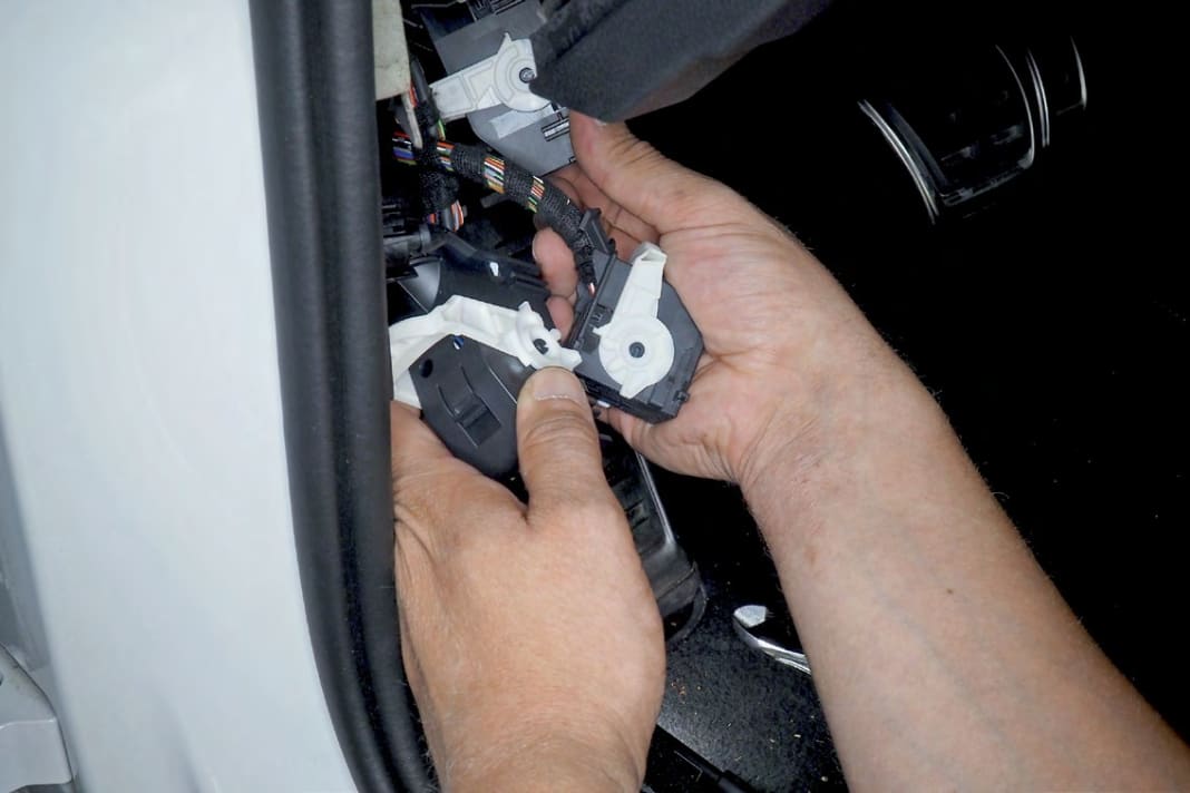 32 Alle drei Stecker am Body-Control-Modul nach Umlegen der weißen Riegel auswerfen; Gehäuse nach Abzwicken des Kabelbinders abziehen
