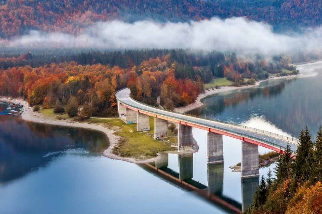 Mit Schwung durchs Land: Die Deutsche Alpenstraße führt auch zum Sylvensteinstausee. Die Faller-Klamm-Brücke, die sie dabei rechts liegen lässt, ist nur einen Katzensprung von der Route entfernt