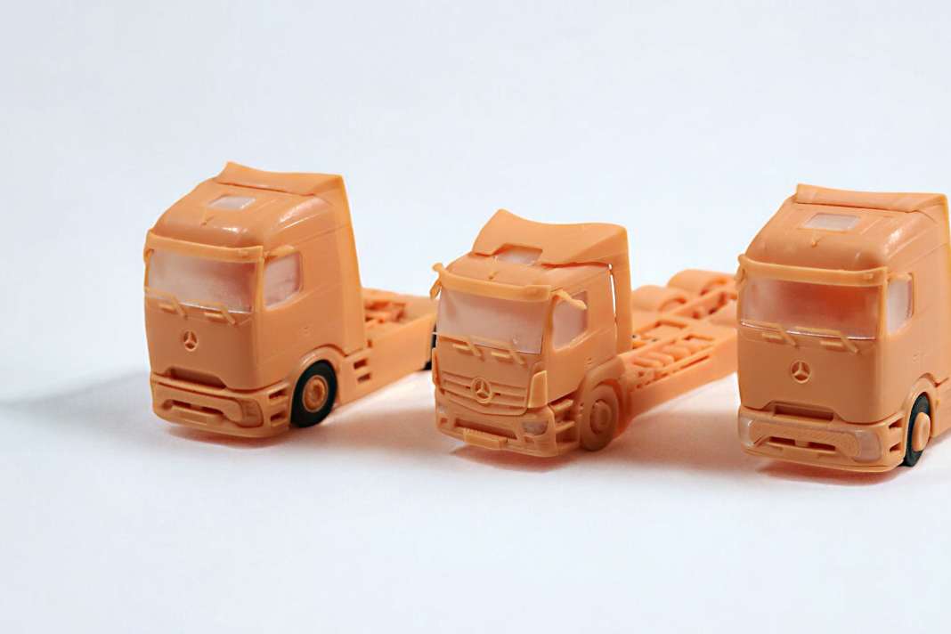 Dreimal Actros von NZG in 1:50: Sattelzugmaschine, eActros 300 und eActros 600 als 3D-Modelle (von links nach rechts)