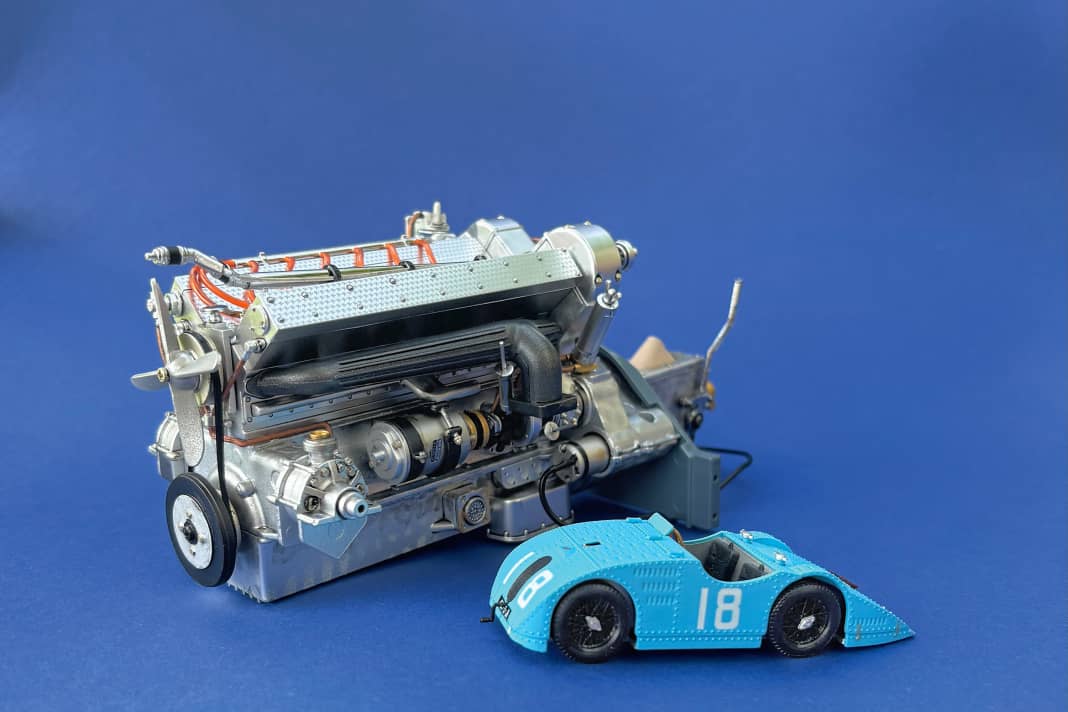 Neben dem bereits montierten 1:8-Motor parkt zum stilechten Größenvergleich ein Bugatti T32 als Verkleinerung in 1:43