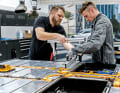 Für einige Arbeitsvorgänge sind zwei Mitarbeiter notwendig. Der direkt an der Batterie tätige Kollege trägt Schutzkleidung