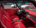 Porsche  964 Turbo 3.6 mit Raffleder im roten Farbton CAn-Can.   Realisiert wurde die Ausstattung von Porsche Exclusive. Edel: die schwarzen biesen im Leder.  Carbon-Applikationen individualisieren die Schalttafel, die Mittelkonsole, den Handbremshebel und den Schaltknauf.