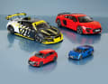 Audi RS 3 Sportback und Audi R8 Coupé in 1:43 (vorne von links), Audi R8 LMS GT2 und Audi R8 Coupé in Misanorot (hinten von links) sind die Stars mit vier Ringen