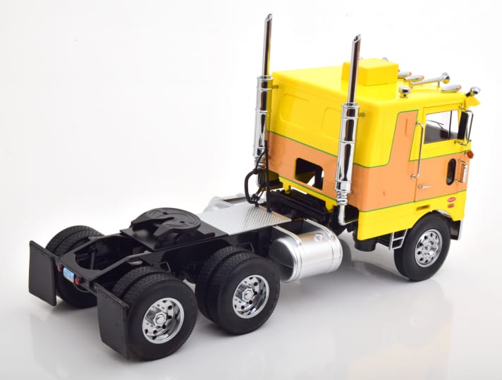 Selbst in der Heckansicht wirkt die zweite Farbversion des Peterbilt 352 Pacemaker von Road Kings in 1:18 noch ausreichend schrill. Dafür sorgt die mutige Farbkombination aus Gelb und Orange ]