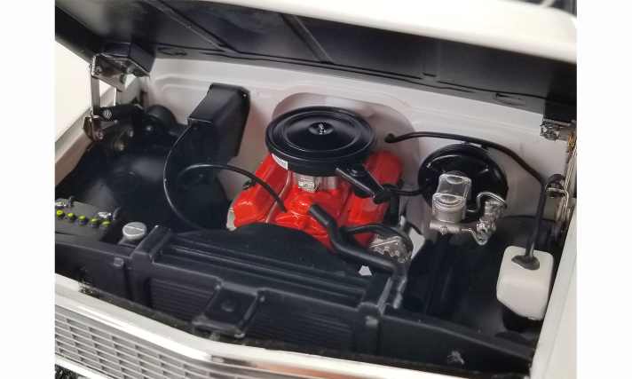 Dieses Foto zeigt den V8 unter der Haube des Blazer-Modells, dessen Block originalgetreu in hellem Rot lackiert ist. Man beachte das Scharnier der Motorhabube aus robusten Metallteilen. ]