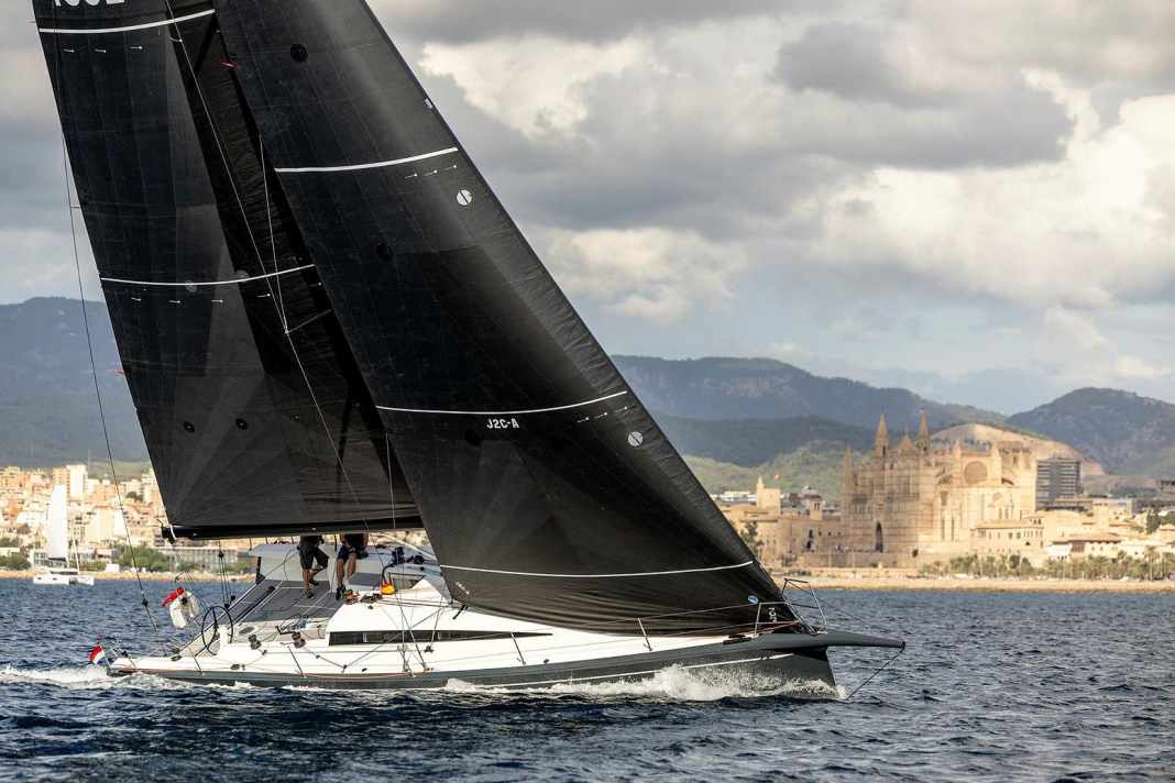 Zwei Hingucker auf einem Bild: die schnittige ClubSwan 43 vor der Basilika von Palma de Mallorca