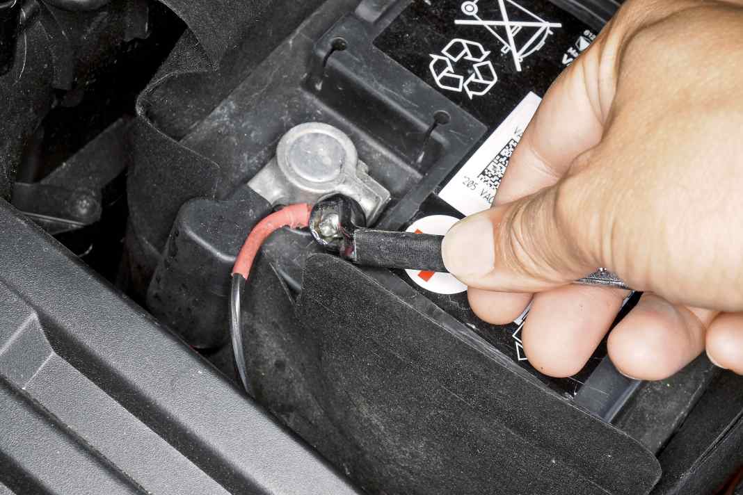 Batterie-Abdeckung öffnen, mit Zehner- Steckschlüssel Polklemme vom Pluspol lösen und beiseite klemmen