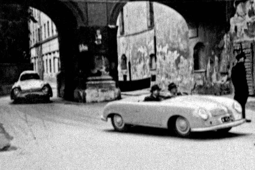 Mit Herbert Kaes am Steuer dreht der Porsche Typ 356 „Nr. 1“ am 11. Juli 1948 beim Stadtrennen in Innsbruck eine schnelle Demorunde. Man beachte den Berlin-Rom-Wagen im Hintergrund