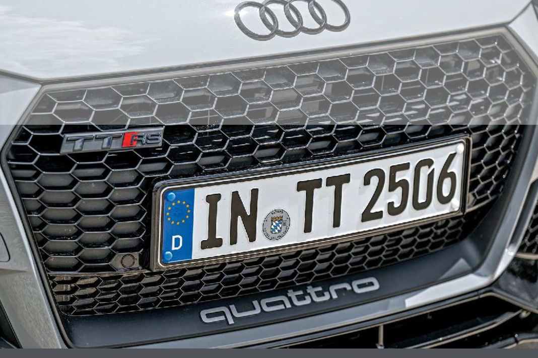 Ein glänzend schwarzer Grill mit matter Singleframe-Einfassung, dazu der titanfarbene Quattro-Schriftzug