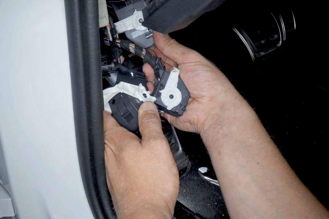 32 Alle drei Stecker am Body-Control-Modul nach Umlegen der weißen Riegel auswerfen; Gehäuse nach Abzwicken des Kabelbinders abziehen