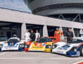 Die Gentleman-Driver kamen im August 2022 in Leizpzig zusammen. In ihrer aktiven Zeit gehörten sie zu den besten Rennfahrern der Welt. Von links: Derek Bell, Jochen Mass, Timo Bernhard, Hans-Joachim Stuck und Bernd Schneider. Hier sind sie an den Fahrzeugen zu sehen, mit dem sie einst die Rennstrecken dominierten. Links parkt der 956-002 Langheck (LH) im Rothmans-Outfit, in der Mitter der 962-009 Kurzheck (KH) im Shell-Design und rechzt der 956-005 Kurzheck in der Racing-Folierung (im Rothmans-Style).