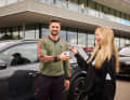 Eine glückliche Audi Mitarbeiterin übergibt die Fahrzeugschlüssel an Torhüter Sven Ulreich.
