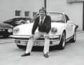 MANFRED WINKELHOCK startete sowohl in der Formel 1 als auch in der Sportwagen-Weltmeisterschaft. In der Formel 1 bestritt er 47 Rennen für Teams wie ATS, Brabham und RAM und holte zwei WM-Punkte. In der Sportwagen-WM siegte er mehrmals. Das Bild zeigt ihn im Sommer auf dem Werksgelände mit seinem neuen 911 Carrera 3.2, der im Januar 1985 gebaut wurde und 231 PS leistet