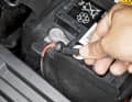 Batterie-Abdeckung öffnen, mit Zehner- Steckschlüssel Polklemme vom Pluspol lösen und beiseite klemmen