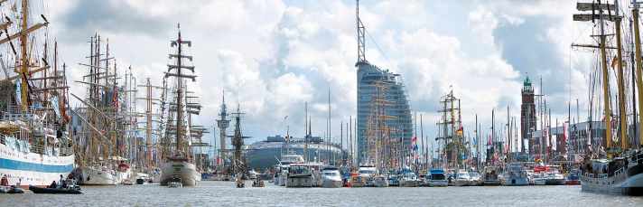 Tradition and modernity meet at Sail Bremerhaven: in the foreground historic windjammers, behind them the modern architecture of the harbour worlds