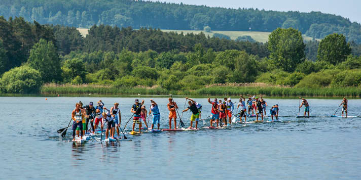 MATERIALREGELN: German SUP League –  Bei allen Distanzen Boards bis 14’ erlaubt; Schüler/Jugend bis 12’6’’. Deutscher Wellen reitverband (DWV) – Boards bis max. 12’6’’ für Flatwater, Technical Race zugelassen. | Sonstiges Equipment: Bei vielen Veranstaltungen besteht eine Leash- und machmal sogar Schwimmwestenpflicht. Auch Kälteschutzkleidung wie Neopren oder ein Trockenanzug kann vorgeschrieben werden. Bei Long-Distance-Wettbewerben benutzen viele SUP-Racer einen Trinkrucksack. Neoprenschuhe sind bei Kälte empfehlenswert.