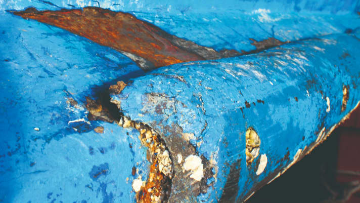 Damaged layers of paint give rust free access to the steel hull.