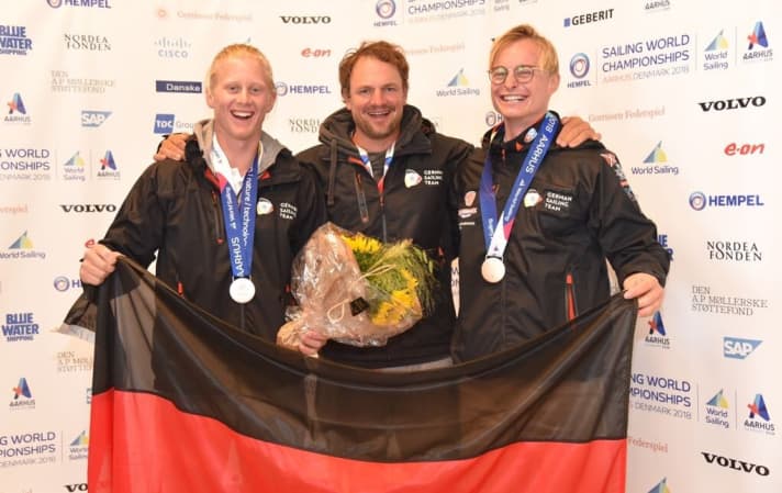   The bronze crew with their coach Max Groy (centre)