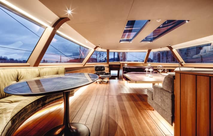 Salon: Next to the dining sofa is an Eames armchair in front of a submerged interior control centre. The windows can be dimmed at the sides and top by touching the display. | n.