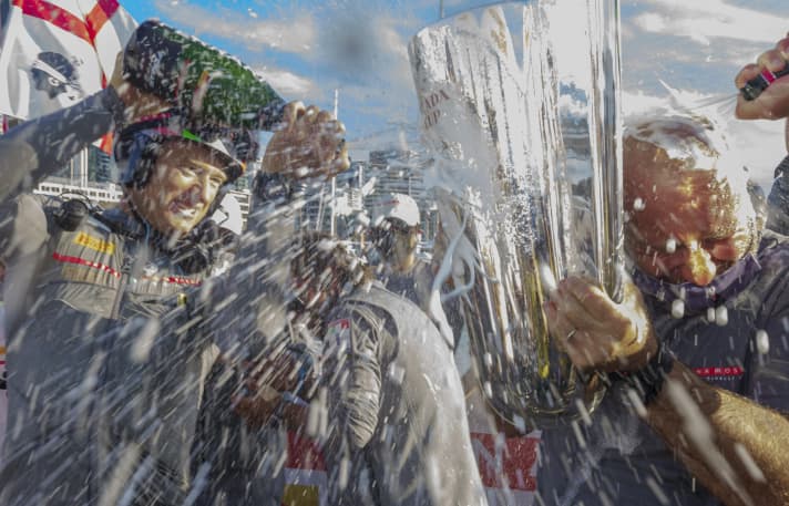   Les Italiens font la fête : le co-barreur Jimmy Spithill (à g.) puise dans ses réserves dans cette scène, le skipper et chef d'équipe Max Sirena est baigné dans le champagne Studio Borlenghi