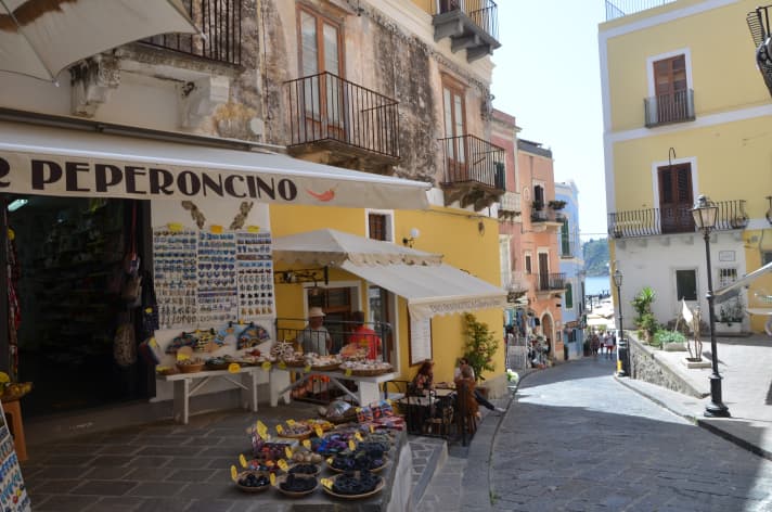   Cappuccino, panini, colourful clothes: the Italian way of life in the small shopping street of Lipari, the largest town in the archipelago