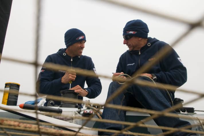   Simon Daubney (r.) one of Team New Zealand's grand old men, helps with the morning preparations