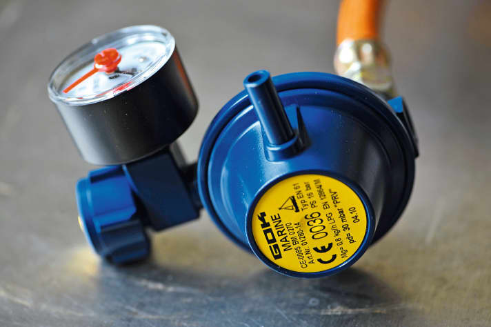   The pressure regulator, shown here with an integrated pressure gauge, reduces the pressure escaping from the cylinder from approx. 7 bar (propane) or 1.2 bar (butane) to the 30 bar operating pressure of the consumers