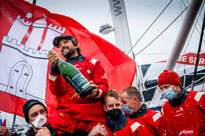   The skipper and his team are happy in front of their home flag: Here Team Malizia celebrates the happy end of the Vendée Globe