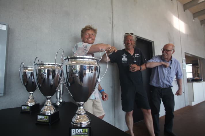   L'impatience est à son comble : Morten Brandt Rasmussen (à gauche) et le directeur de la régate Jens Villumsen (à droite) saluent le soliste Harmen de Jong. Le Hollandais était déjà arrivé jeudi à Aarhus avec son HOD 35 "Xtra Hod" lorsqu'il s'est rendu compte qu'il avait emporté une grand-voile trop lourde. Il a emprunté une voiture, a parcouru 600 kilomètres pour rentrer chez lui, a pris une grand-voile plus légère, a profité d'un dîner avec ses filles et est retourné le lendemain à Aarhus, où il prend aujourd'hui le départ du Round Denmark avec 20 autres solitaires.