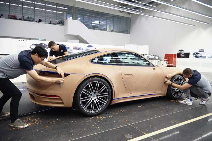 Am 1:1 Clay-Designmodell findet die Designentwicklung statt. Die Modelleure modellieren die Form und erarbeiten mit Hilfe der Tapes den Formverlauf.