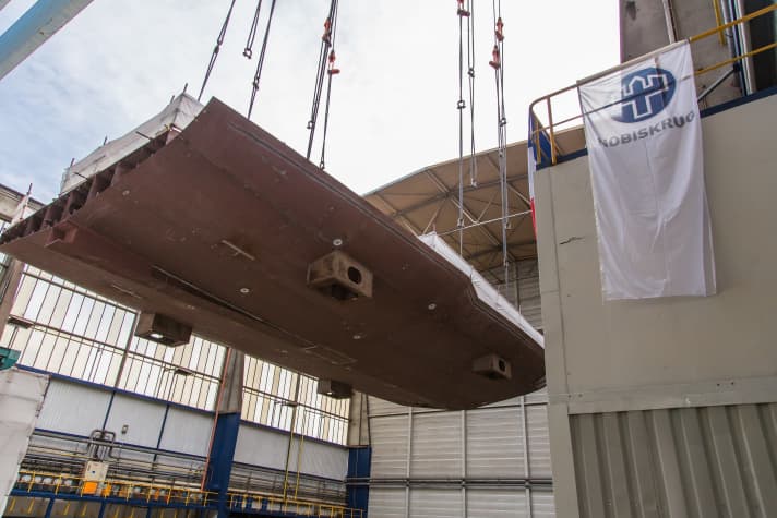 The gantry crane lifted the 80-tonne floor section into the shipbuilding hall. | e.