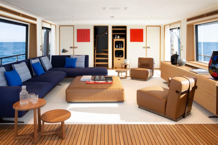 Hauptsalon: Citterio Viel lassen das Teakdeck nach innen weiterlaufen und setzen auf Teak-Rahmen, Design-Mobiliar und Schnittbilder von Lucio Fontana. | a.