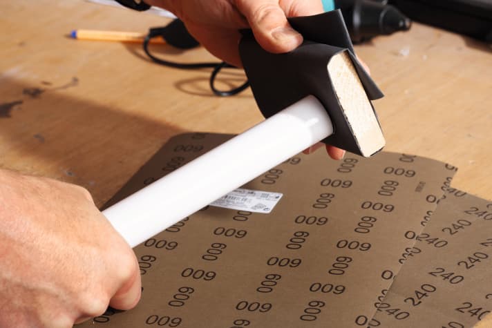 Anschließend wird das Rohr mit einem ebenen Stück Holz und 240er Nass-Schleifpapier entgratet.