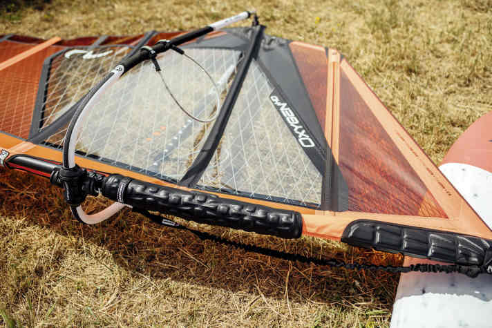 Instead of on the boom as in the past, an attachable pad is more useful on the mast in modern set-ups, because it hits the nose of the board in a crash.