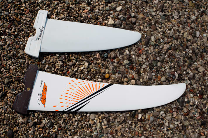 All brands have significantly larger fins on their centreless step-up boards. The centreboards can be steered better with the smaller fin in light winds, the weightless boards glide better with the large fin in stronger winds.