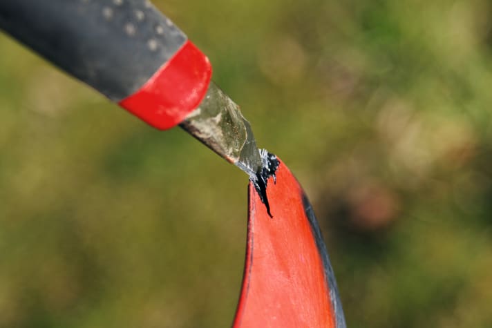 Das Finnen-Tip abzusägen wäre nur die absolute Notlösung. Versuche stattdessen erstmal mit einem Cuttermesser vorsichtig lose Bruchstücke zwischen den Lagen zu entfernen.