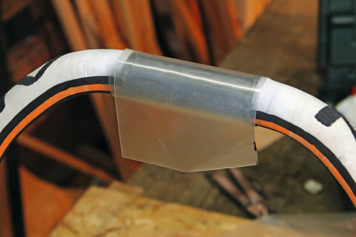 Wrap this piece of rubber around the spar two to three times (depending on the amount of play).