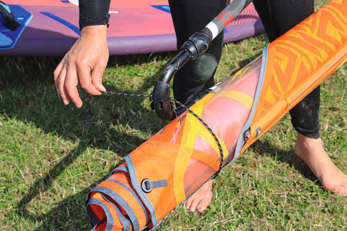 ...and place the outhaul rope loop around the sail. Only pull moderately tight here so as not to squeeze the sail's mono film too much. If you are using an uphaul rope, you can also use it to fix the sail to the front of the boom.