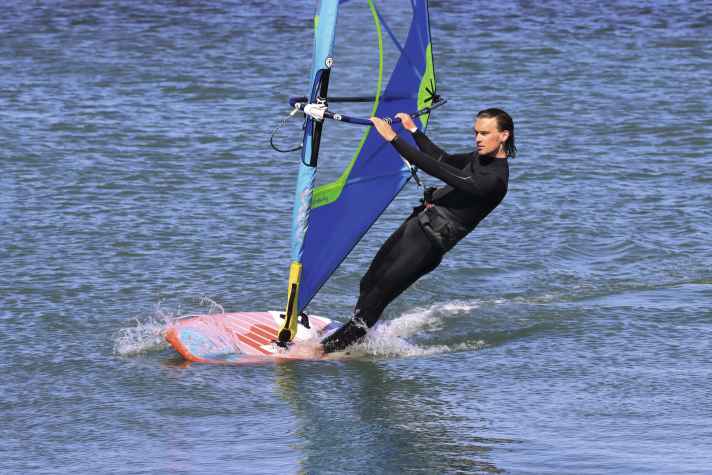 Sailing upwind without a centreboard is only possible when tacking if you maintain constant pressure on the windward edge. This minimises lateral drift.