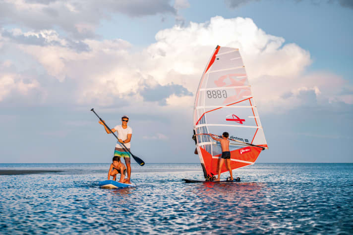 Die Dorf-Kinder belagert die Windsurfer, als ob sie vom Mars kämen